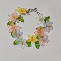 bracciale circondato da fiori di diversi colori e foglie verdi